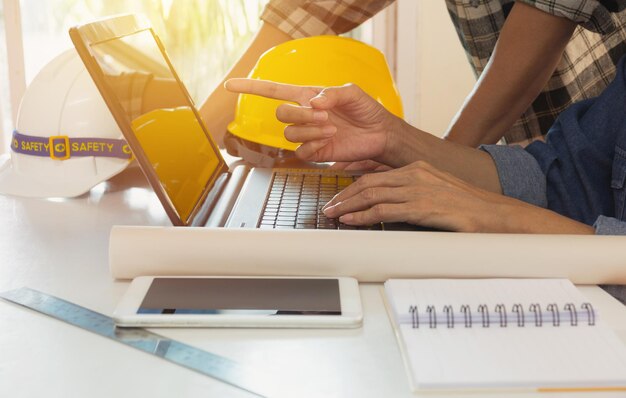 Midsection of architects using laptop on desk