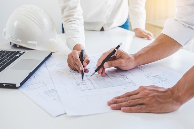 Midsection of architects working on blueprint