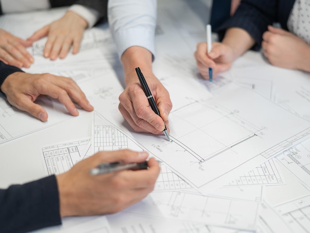 midsection of architects working on blueprint