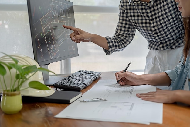 Foto sezione centrale di architetti che lavorano su un tavolo in ufficio