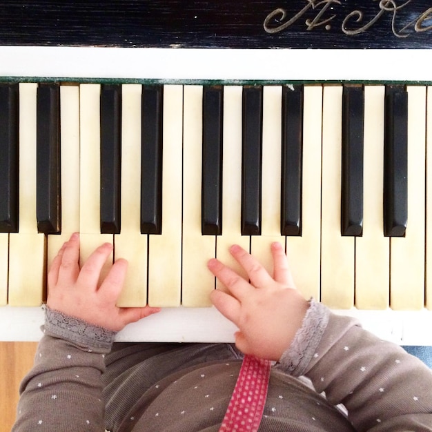 Foto sezione centrale di un bambino che suona il pianoforte