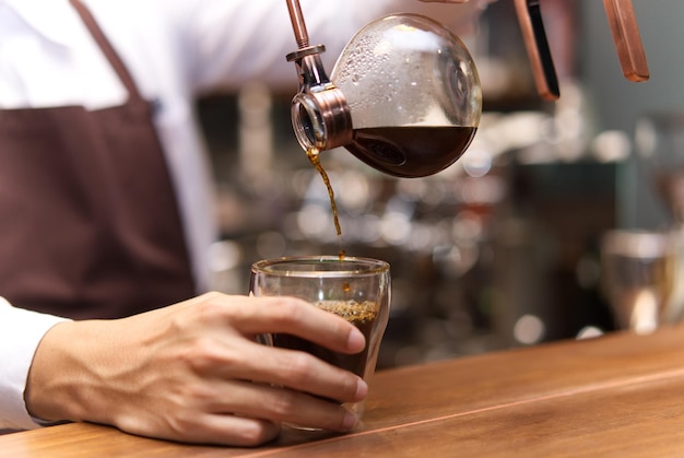 カフェでコーヒーを作っているバースタのミッドセクション