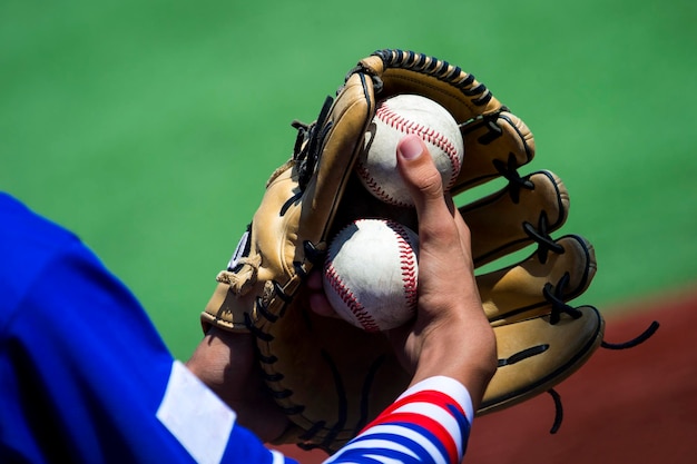 Foto sezione centrale di un giocatore di baseball che tiene un guanto e delle palle