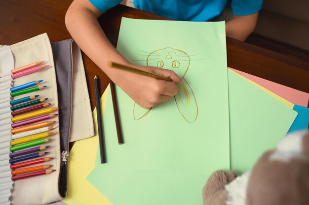 midsection of boy drawing on paper