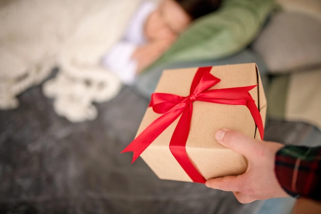 クリスマスのプレゼントを握っている男の子のミッドセクション