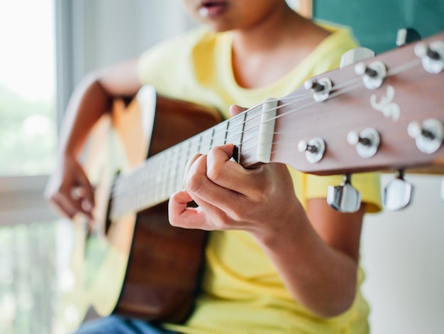 midsection of boy playing guitar