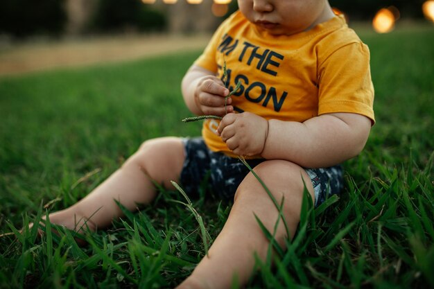 Photo midsection of boy sitting on field