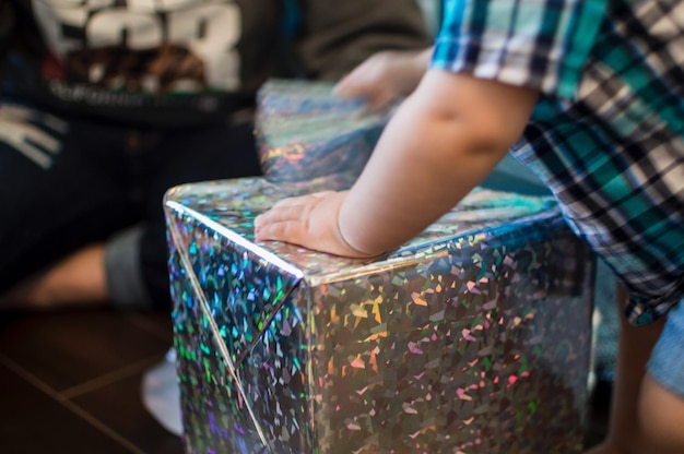 Photo midsection of boy wrapping gift box at home