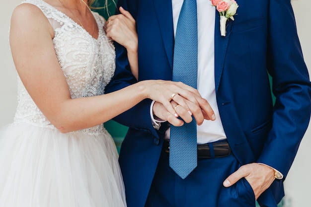 結婚式中に手をつないでいる新郎と新婦のミッドセクション