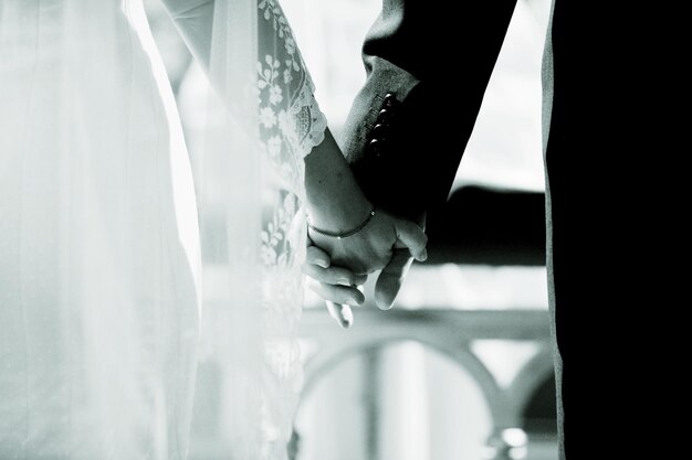 Photo midsection of bride and bridegroom holding hands