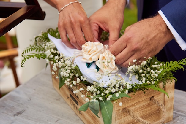 Foto sezione centrale della sposa e dello sposo con i fiori durante la cerimonia nuziale
