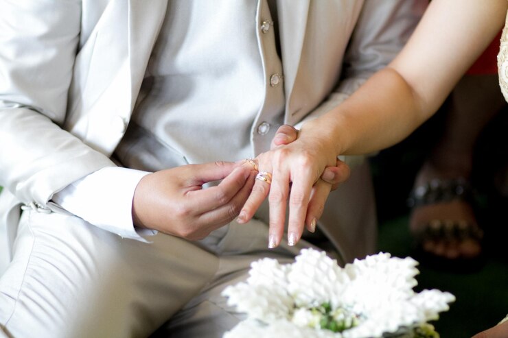 Photo 結婚式中に指輪を交換する新郎と新婦のミッドセクション