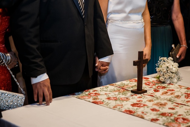 Midsection of bride and groom holding hands during wedding ceremony
