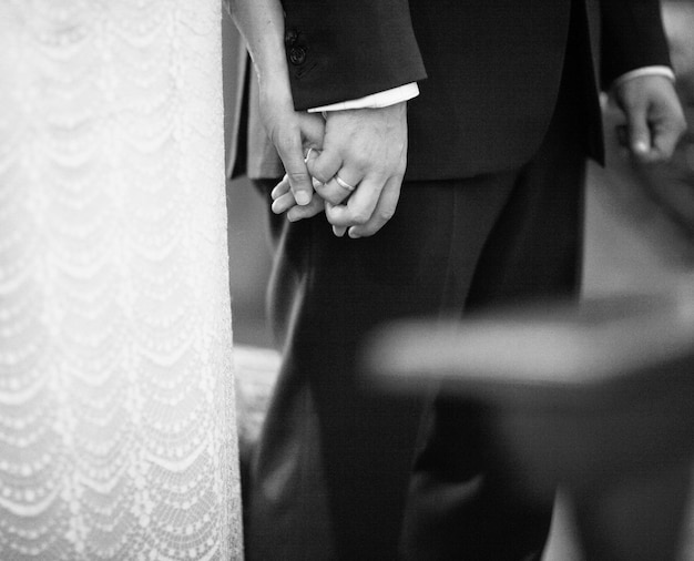 Midsection of bride and groom holding hands