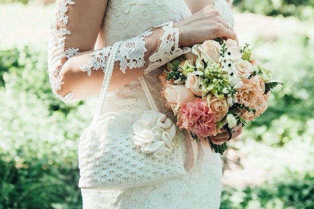 midsection of bride holding bouquet