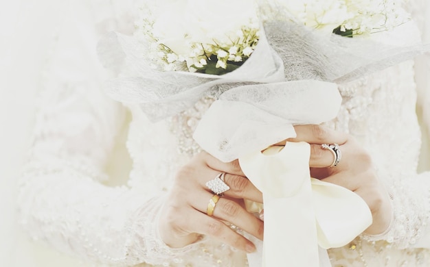 Foto sezione centrale della sposa che tiene un bouquet