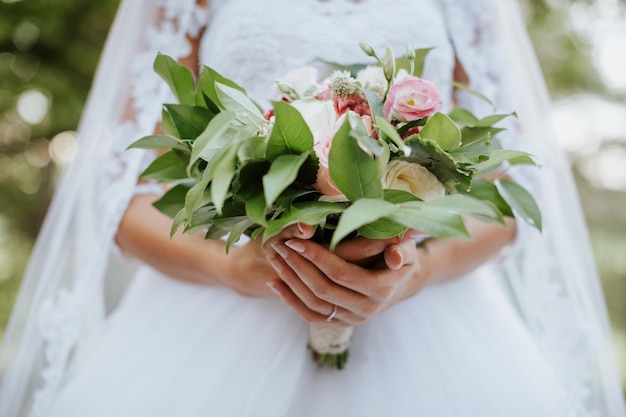 midsection of bride holding bouquet