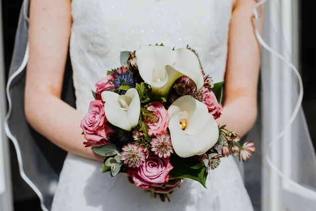 Photo midsection of bride holding bunch of flowers