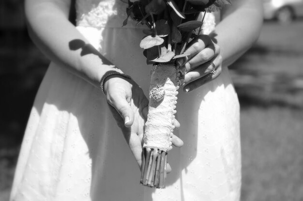 Photo midsection of bride holding bunch of flowers