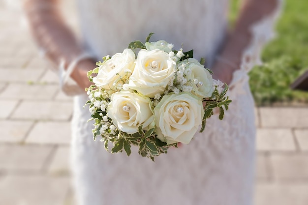 midsection of bride with bouquet