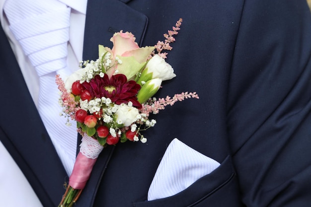 結婚式中に花束を飾ったスーツを着た新郎のミッドセクション