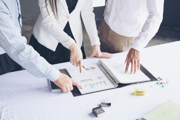 Midsection of business colleagues discussing over documents in office