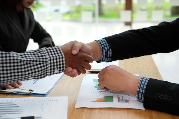 Photo midsection of business people shaking hands on table