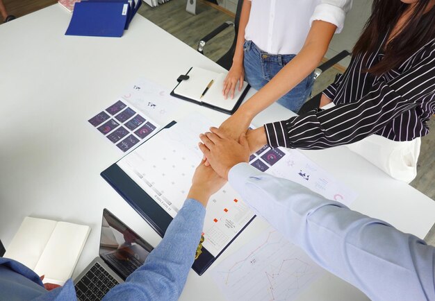 Photo midsection of business people stacking hands on table