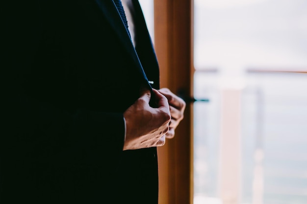 Midsection of businessman adjusting suit