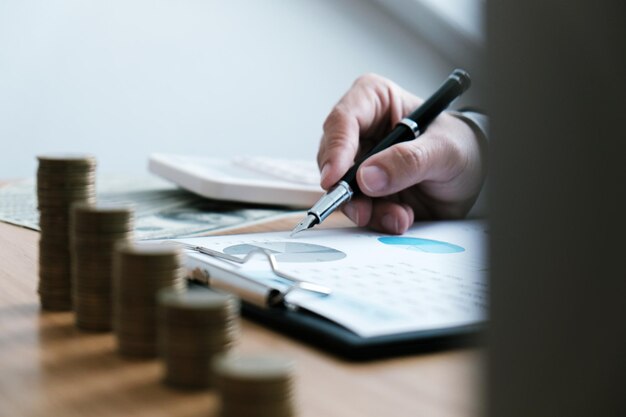 Photo midsection of businessman analyzing graphs on desk in office