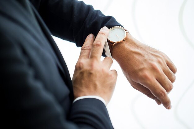 Midsection of businessman checking time in office