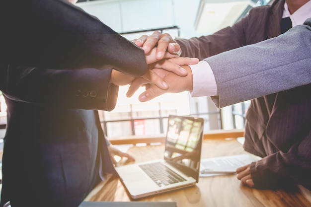 Photo midsection of businessman and colleagues stacking hands