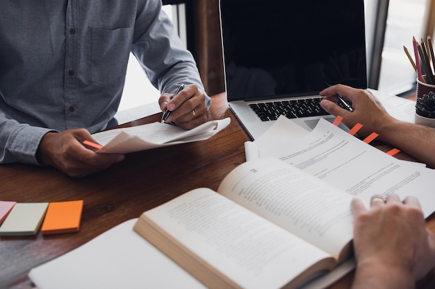 Photo midsection of businessman discussing with colleague at desk in office