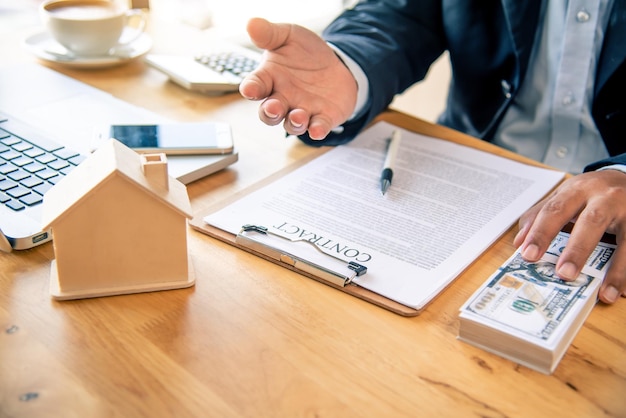 Midsection of businessman giving hand at table in office