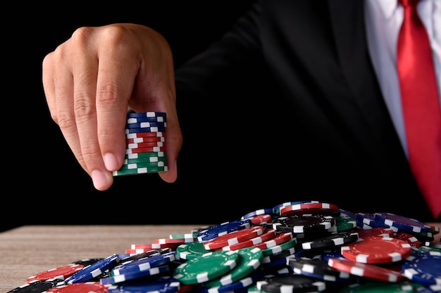 Photo midsection of businessman holding gambling chips against black background