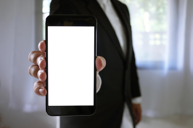 Foto sezione centrale di un uomo d'affari con un telefono cellulare in piedi in ufficio