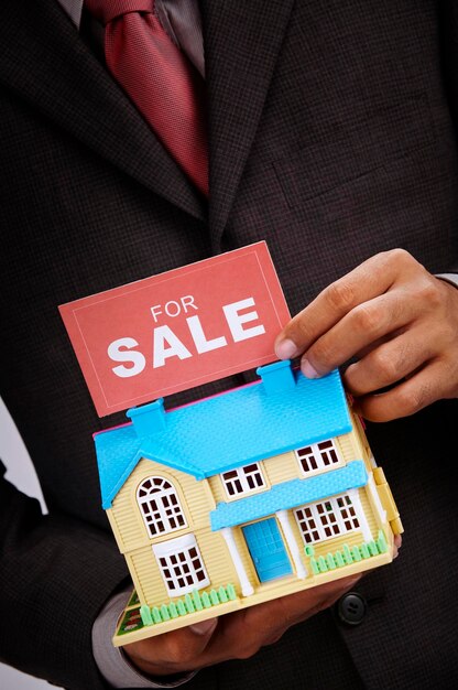 Photo midsection of businessman holding model home