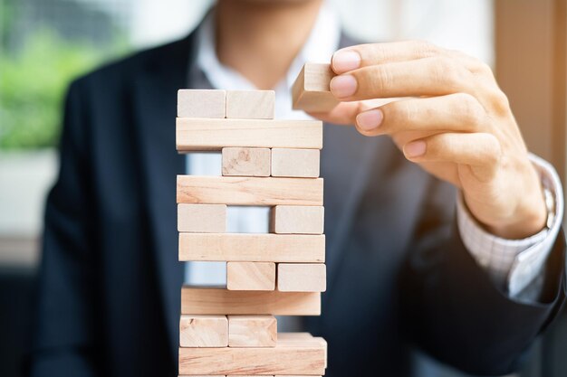 Midsection of businessman playing with toy blocks on table