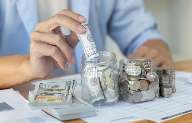 Midsection of businessman putting coin in office