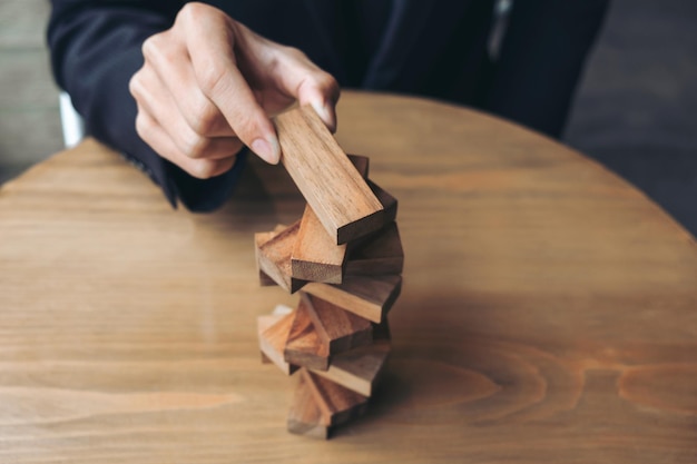 Midsection of businessman stacking wooden blocks on desk