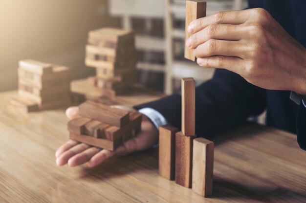 Photo midsection of businessman stacking wooden blocks on table