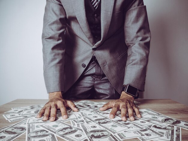 Midsection of businessman standing by paper currencies