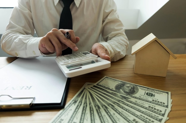 Midsection of businessman using calculator graph on table