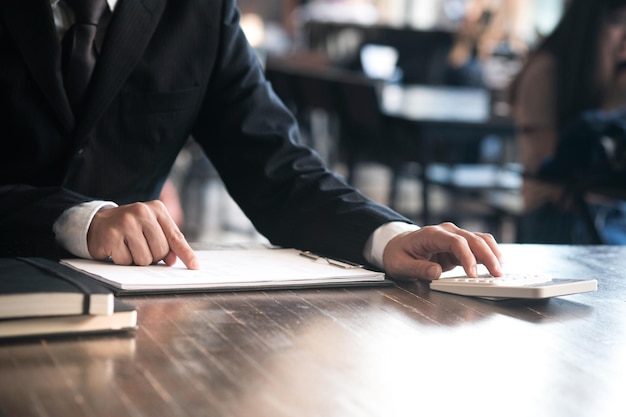 Photo midsection of businessman using calculator