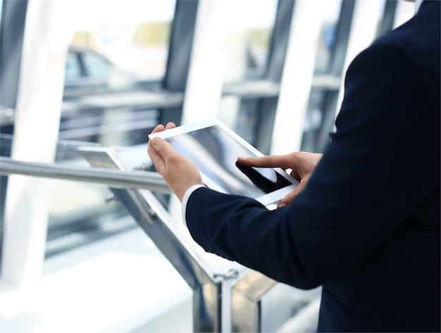 Midsection of businessman using digital tablet in office