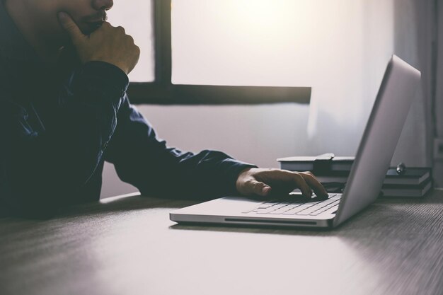 Midsection of businessman using laptop at desk in office