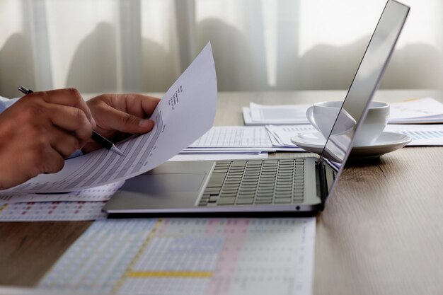 Midsection of businessman using laptop on table