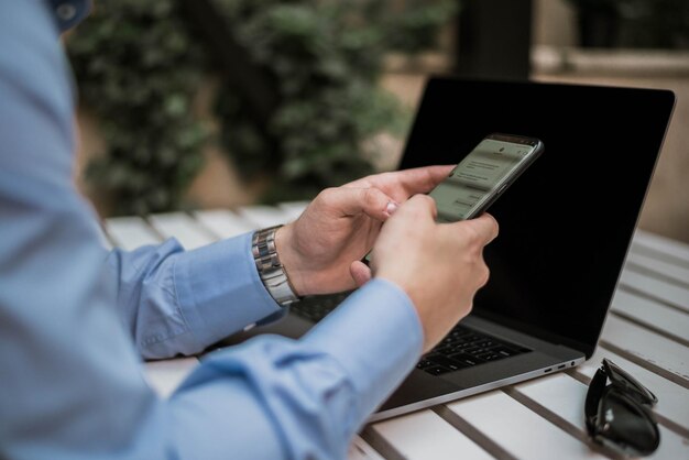 机の上で携帯電話を使っているビジネスマンのミッドセクション