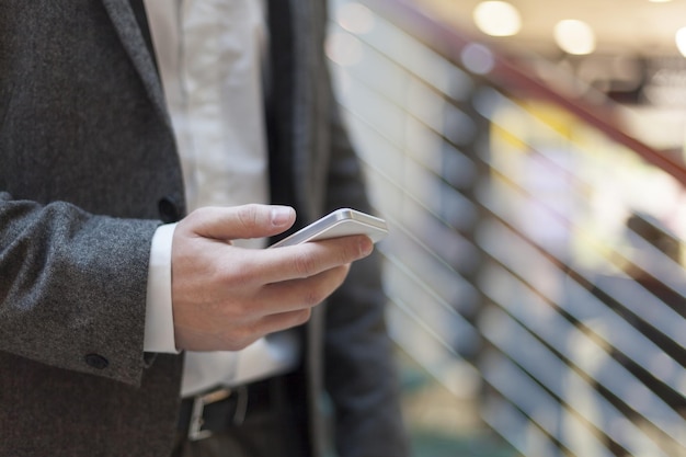 Photo midsection of businessman using mobile phone in office