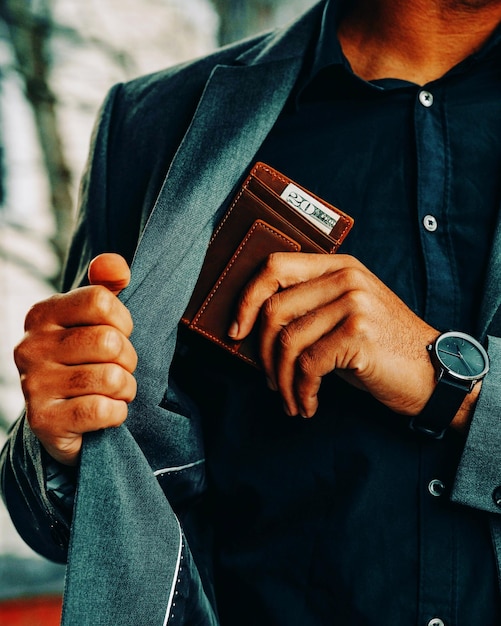 Midsection of businessman using mobile phone